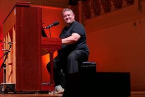 Ein Bild, das Kleidung, Mikrofon, Person, Im Haus enth�lt.

Automatisch generierte Beschreibung